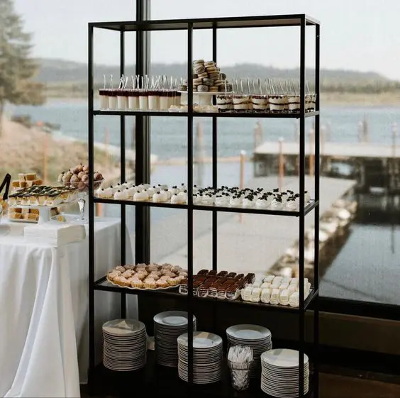 a black storage shelf as an additional piece for the wedding dessert table