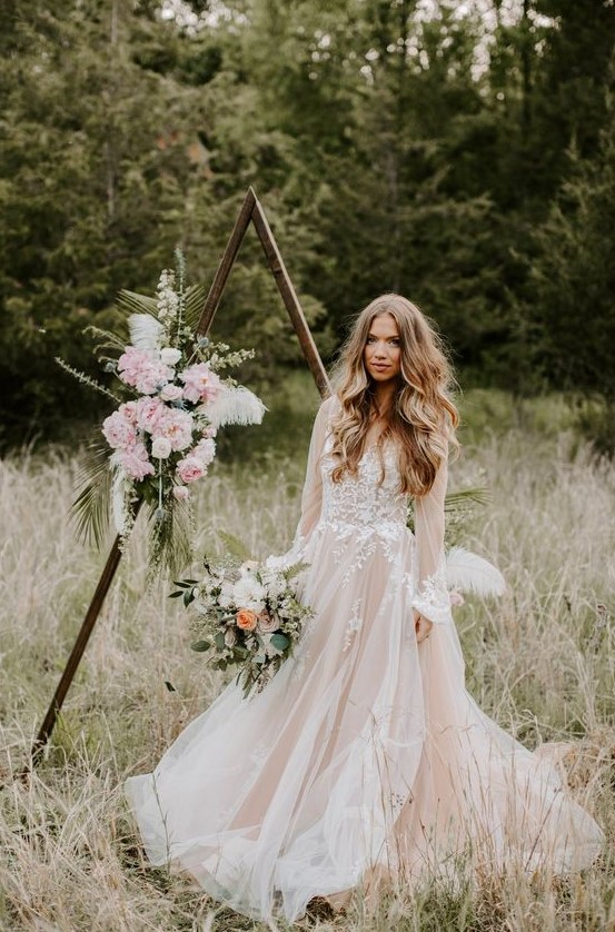 a blush A-line wedding dress with long sleeves and a V-neckline plus white lace is a dreamy idea to feel a princess