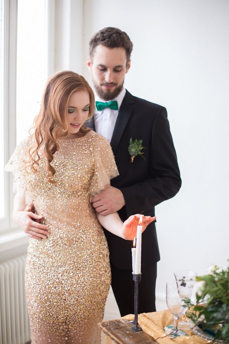 a bride rocking a gold embellished wedding dress, green eyeshadows, a groom rocking a black suit and an emerald bow tie