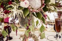 a bright and glam wedding tablescape with a gold sequin runner, marsala glasses and apples, blooms and drinks