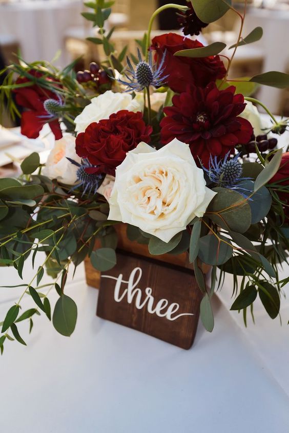 a bright wedding centerpiece of marsala, white blooms, eucalyptus and thistles is a lovely idea for a rustic wedding