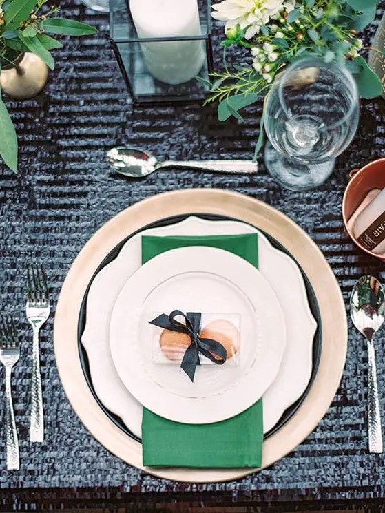 a chic gold and emerald table setting with a black sequin tablecloth as a chic backdrop