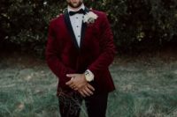 a chic groom’s outfit with a burgundy velvet blazer with black lapels, a black bow tie, black cropped pants and moccasins