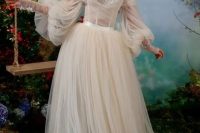 a fairy tale off the shoulder wedding dress of blush tulle, with a lace corset and puff sleeves for a royal-like look