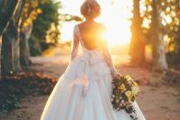 a gorgeous princess style wedding dress with a lace bodice and long sleeves, a cutout back and a pleated skirt with a train is wow