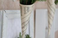 a greenery wreath and evergreens in paper cones make the wedding aisle look vintage, natural and chic