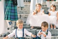 a groom, groomsmen and ring bearers all wearing green tartan kilts to commemorate the heritage of the groom