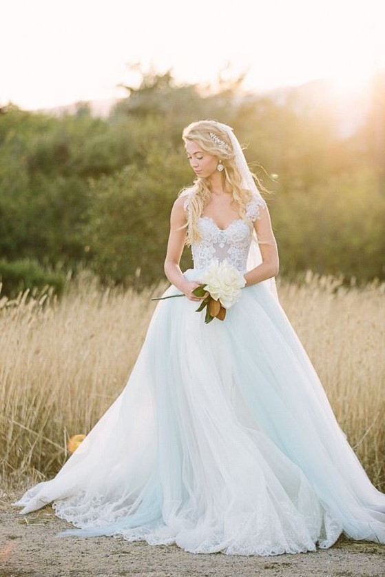 a light blue princess-style wedidng ballgown with a lace bodice and thick straps and a layered skirt