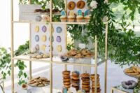 a modern wedding dessert shelf with colorful geodes, lots of greenery, white blooms and signs is all cool