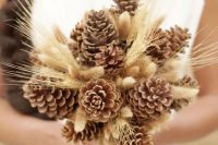 a rustic wedding bouquet of pinecones and wheat is cool for a fall or winter wedding