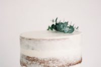 a simple single layered naked wedding cake topped with fresh eucalyptus for a minimalist wedding