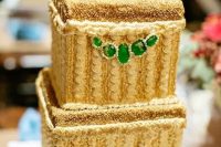 a stunning sparkly gold wedding cake with emeralds looks wow and is ideal for an art deco wedding
