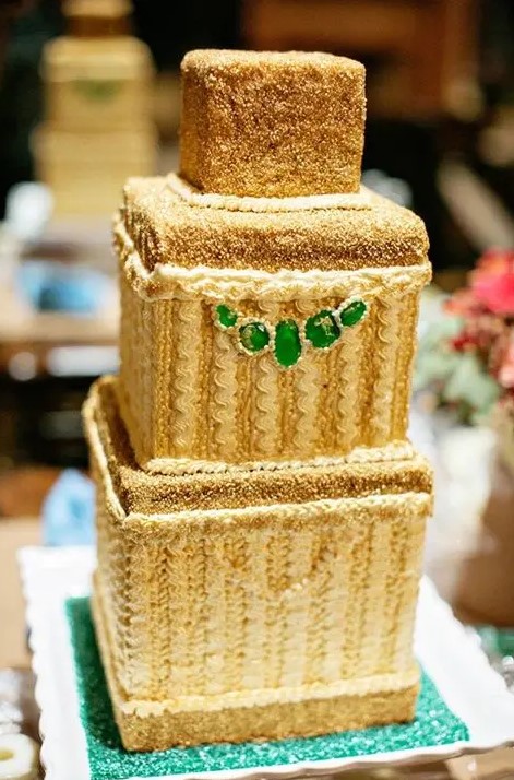 a stunning sparkly gold wedding cake with emeralds looks wow and is ideal for an art deco wedding