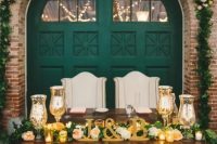 a vintage emerald barn door as a backdrop, gold candleholders, letters and a lush greenery garland