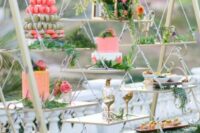 a wedding dessert swing decorated with greenery and bright blooms is a lovely alternative to a usual wedding dessert table