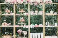a wedding dessert table alternative composed of several gilded shelving units, with calligraphy and neutral blooms on top is a lovely idea