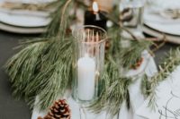 an airy table runner with pine branches, pinecones and candles make the tablescape very chic and holiday-like