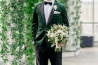 an elegant groom’s look with an emerald velvet blazer with black lapels, a bow tie and black shoes