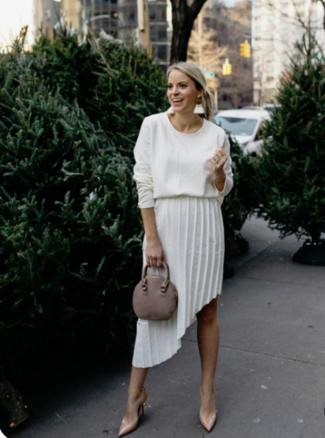 blush heels, a pleated asymmetrical skirt, a white top and a mauve bag for a modern bride-to-be