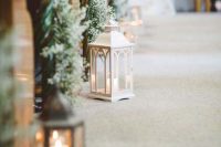 evergreen and baby’s breath posies and candle lanterns will give your wedding aisle a winter wonderland feel