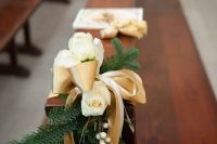 evergreens, white roses and berries, gold and neutral ribbon bows will accent your wedding aisle in a traditional holiday way