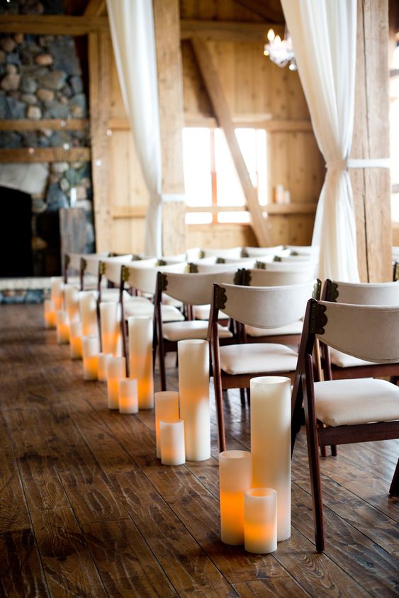 lamps imitating candles in tall candleholders are great for decorating a winter wedding aisle and bring coziness to the space