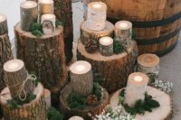 tree stumps with moss, greenery, some blooms and candles in wooden candleholders for lovely woodland decor