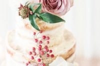 a beautiful naked wedding cake topped with berires, blush, white and red blooms and greenery is wow