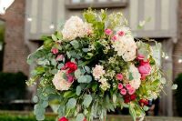 a beautiful oversized wedding centerpiece of white, pink and red blooms and lots of greenery for Valentine’s Day