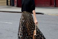 a black oversized top, a black and gold geometric midi skirt, black strappy shoes and a brown bag