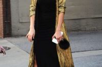 a black slip midi dress with a side slit, black strappy shoes, a shiny gold duster and a black bag