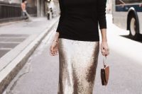 a black turtleneck, a gold sequin pencil midi, black sock booties and a brown bag with a ring handle