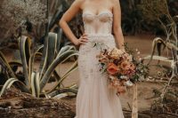 a blush mermaid wedding gown with a strapless sweetheart neckline and a pleated skirt, a train and embroidery and embellishments
