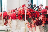 a bold red floral centerpiece – a box with bright blooms and leaves and some neutral candles for a chic look