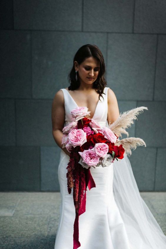a bright Valentine wedding bouquet with pink and red roses, amaranthus and pampas grass is wow