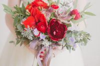 a bright Valentine wedding bouquet with red, pink and fuchsia blooms, purple succulents, greenery and lavender ribbons