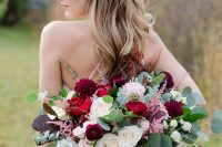 a bright and chic Valentine wedding bouquet of red, burgundy, white roses and dahlias, pink blooming branches, usual and dark foliage