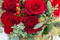a bright and traditional red rose Valentine wedding bouquet with berries and greenery is bold and timeless
