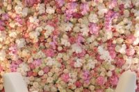 a bright flower wall with pink, blush and white blooms coverign the whole piece and making it more refined
