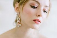 a bright spring wedding makeup with a bright pink glossy lip, peachy eyeshadow, a touch of pink blush, accented eyebrows