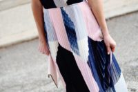a chic modern pleated midi dress with an abstract print in navy and pink, white shoes and a white clutch