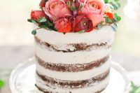 a chic naked wedding cake topped with red, pink and burgundy blooms and greenery for a Valentine wedding