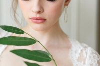 a fresh pink wedding makeup with a glossy pink lip, pink eyeshadow, a touch of blush and eyes accented with faux eyelashes