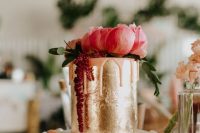 a gold foil wedding cake with pink dripping, pink and fuchsia blooms and greenery is a refined idea for a Valentine wedding