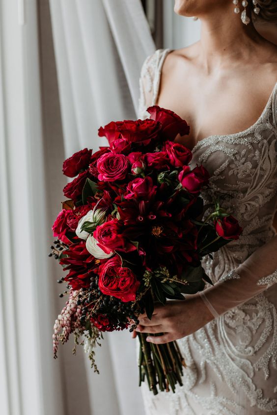 a gorgeous red rose wedding bouquet with greenery and berries is a stylish idea for a Valentine's Day bride