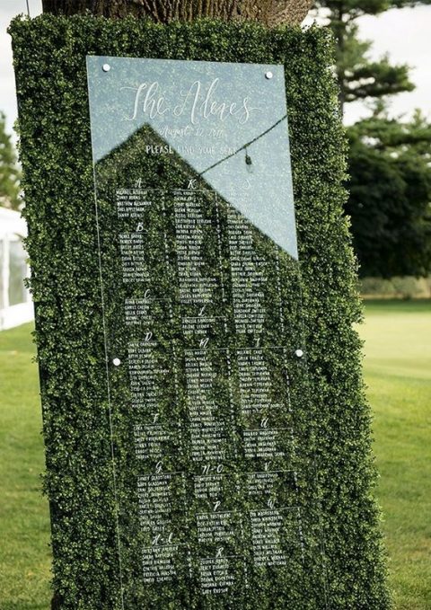 a greenery wall and acryl wedding seating chart looks modern, bold and very fresh