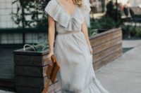 a grey polka dot maxi dress with ruffles, lace inserts, a brown clutch and brown strappy shoes