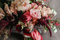 a jaw-dropping Valentine wedding bouquet of creamy, pink and deep burgundy blooms, berries and pink ribbons
