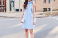 a light blue mini dress with a halter neckline, a bow, grey shoes and a nude box clutch for a spring wedding