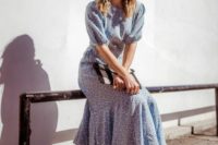 a light blue printed midi dress with an asymmetrical skirt, short sleeves, a high neckline, black shoes and a striped clutch
